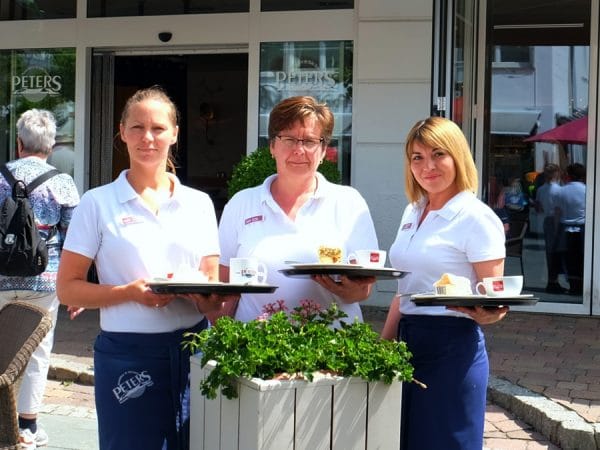 Roxana Röder, Korina Kuhnke und Aksana Vrcek (v.l.n.r.) auf der Terrasse des Café Bäckerei Peters Binz.